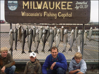 group of 4 in front of the fish they caught on Lake Michigan