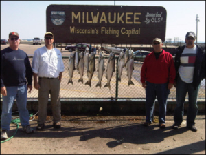 group of 4 in standing in front of the fish they caught